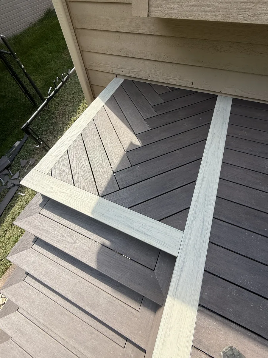 Overhead detail of diagonal deck boards and a light-colored picture-frame border