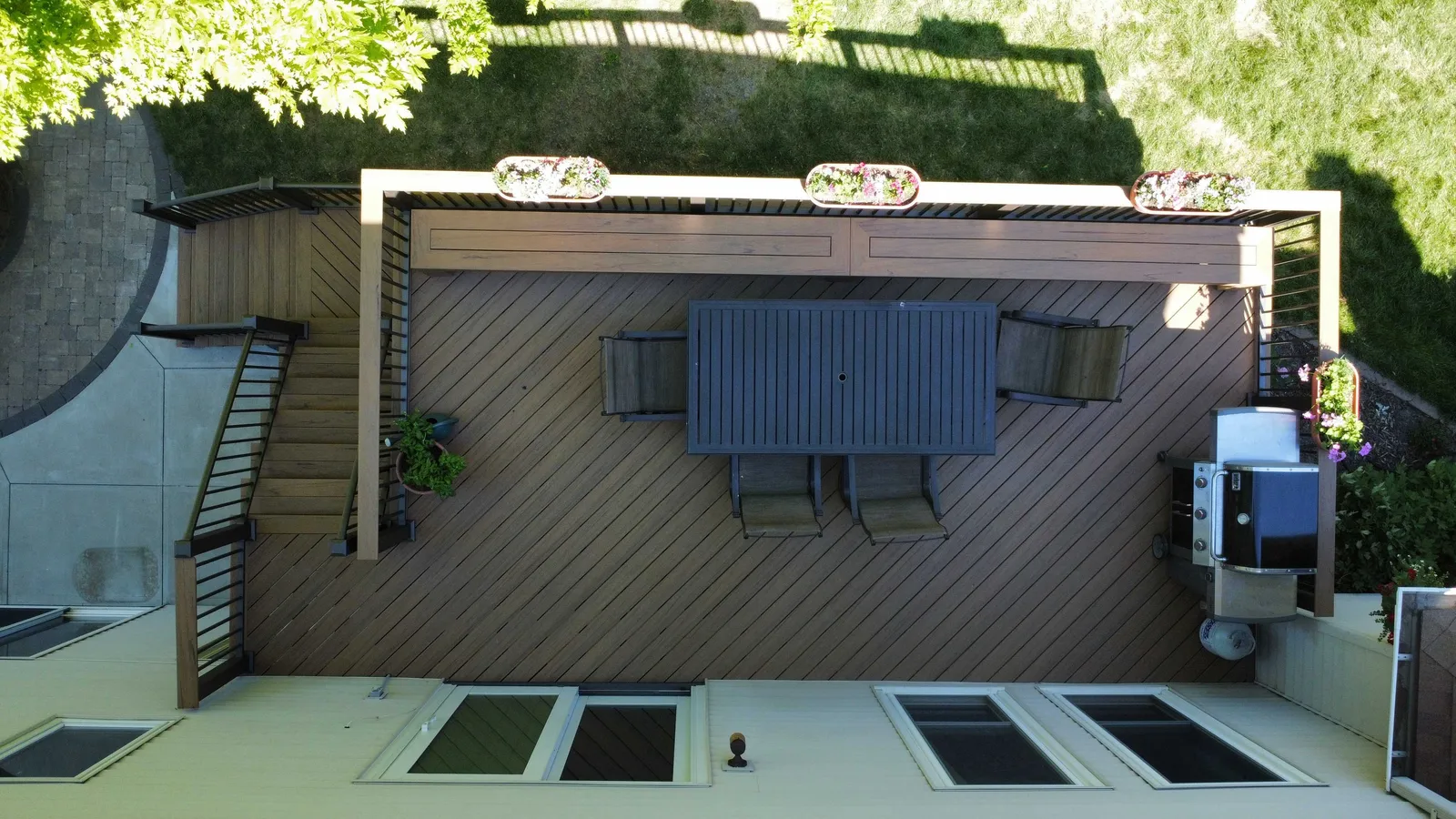 Overhead view of an outdoor dining deck with wide-top railing and flower boxes