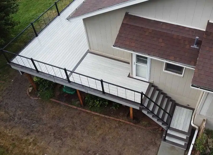 Overhead view of a raised deck with dark railing and stairs leading to the yard