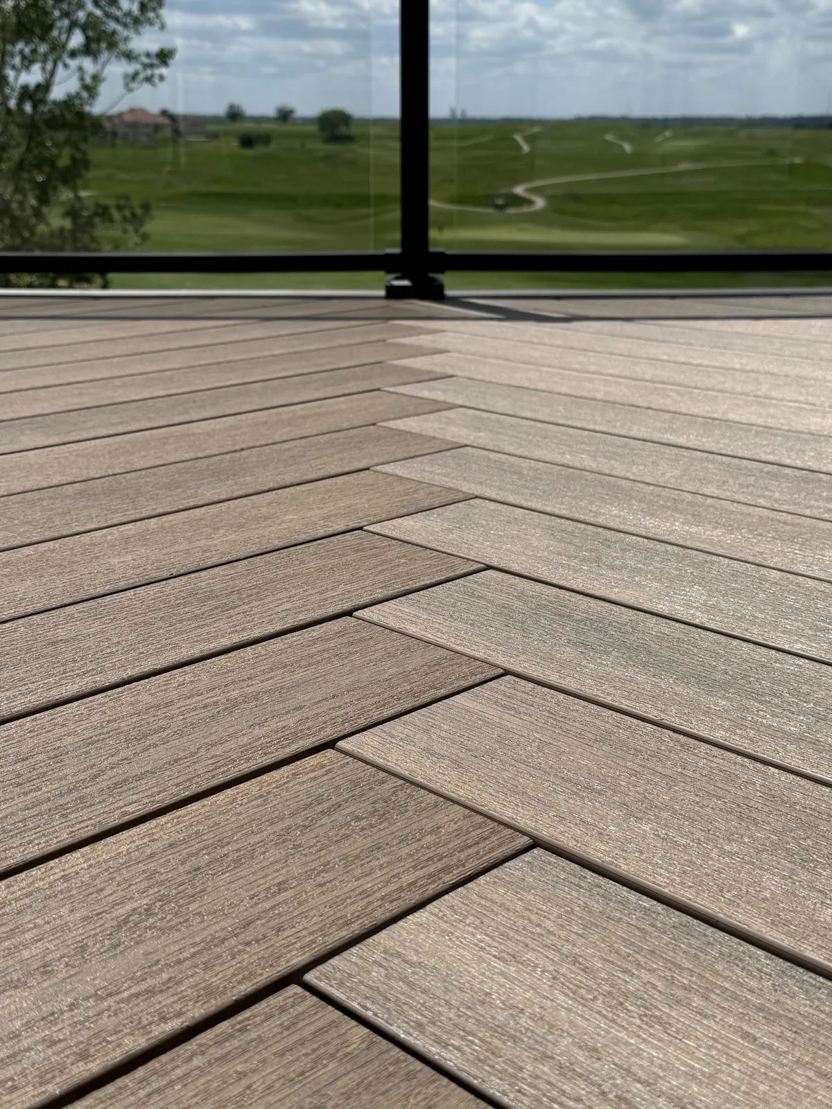 Patterned deck boards beside a black railing