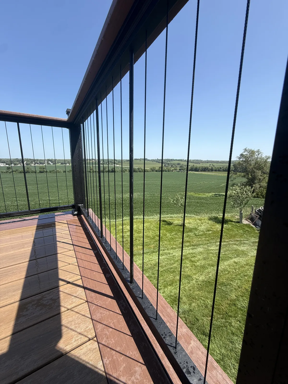 Deck with black railing overlooking an open landscape